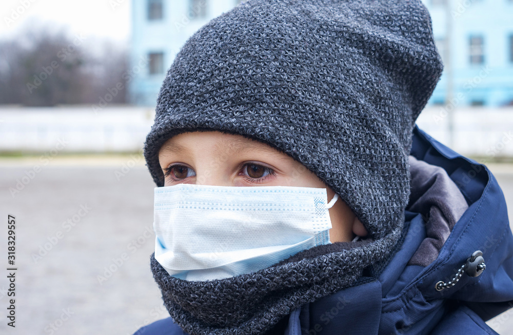 Portrait of young boy in protective medical mask. Protection against influenza and the viral epidemic, quarantine at school, concept image. Portrait of young boy in protective medical mask. Protection against influenza and the viral epidemic, quarantine at school, concept image.