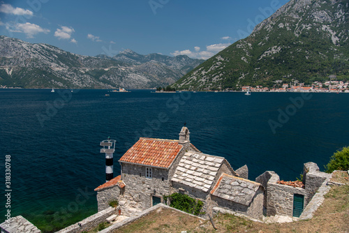 Bay of Kotor, also known as Kotorska Boka, during a quiet summer afternoon with mountains reflecting in the waters of the Adriatic sea. © precinbe