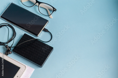 A light blue table with the necessary items on it. Diary with pen  Samsung phone. White cup of coffee. Top view with copy space 