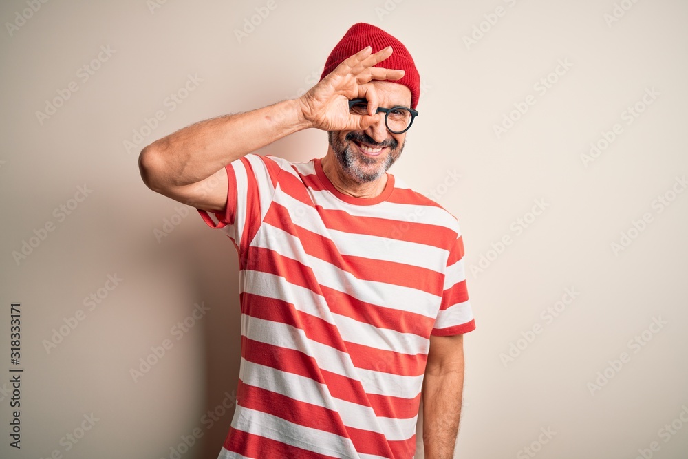 Naklejka premium Middle age hoary man wearing striped t-shirt glasses and cap over isolated white background doing ok gesture with hand smiling, eye looking through fingers with happy face.