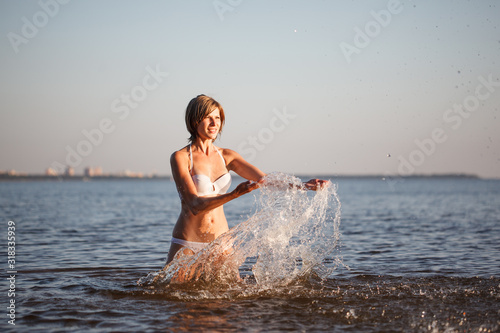 Woman enjoys on beach. Girl jumps on  waves and laughs. Model in swimsuit on  ocean vacation. Tourism and rest