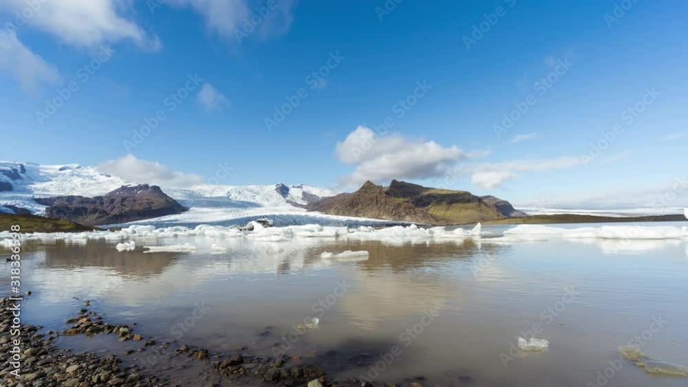 Time lapse of the lagoon of the Fjallsárlón glacier on a sunny day with moving clouds