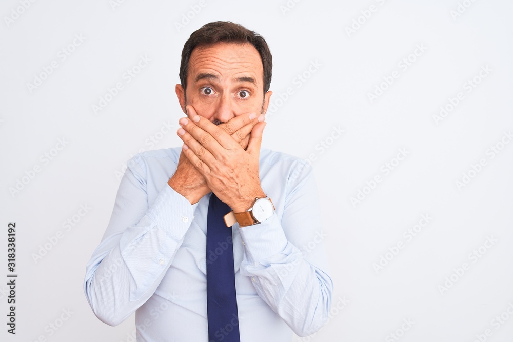 Middle age businessman wearing elegant tie standing over isolated white background shocked covering mouth with hands for mistake. Secret concept. Middle age businessman wearing elegant tie standing over isolated white background shocked covering mouth with hands for mistake. Secret concept.