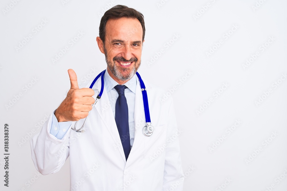 Middle age doctor man wearing coat and stethoscope standing over isolated white background doing happy thumbs up gesture with hand. Approving expression looking at the camera showing success. Middle age doctor man wearing coat and stethoscope standing over isolated white background doing happy thumbs up gesture with hand. Approving expression looking at the camera showing success.