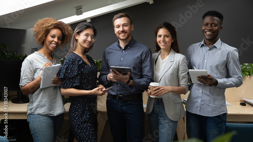 Slika na platnu Group portrait of smiling multiethnic team posing in office