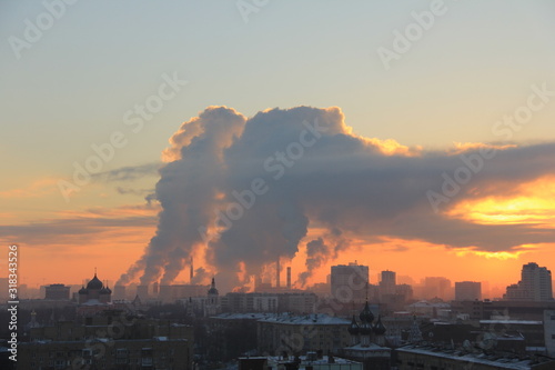 Sunset over the city with steam from TPP pipes