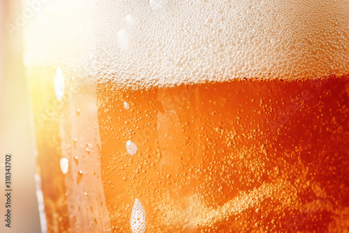 Close up gold background texture of yellow lager beer with froth and bubbles ...