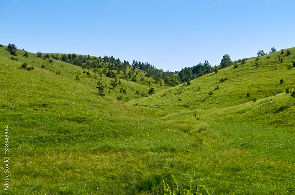 Idyllic mountain landscape - with hills, pastures, fields and valleys - in spring