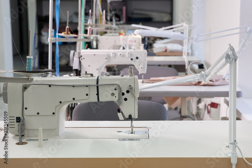 Row of sewing machines in atelier studio or tailor shop photo