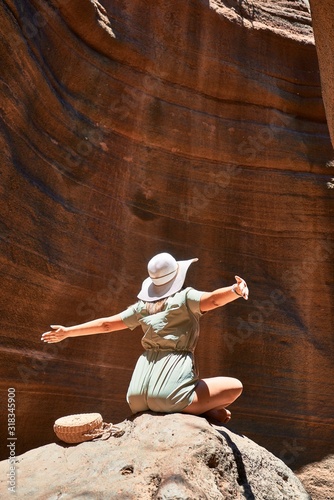 Young beauitufl hiker woman trekking natural orange mountain with arms raised celebrating summer holidays