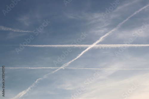Air liner leaving a trace of exhaust gases glowing in the sun. Ecology of passenger traffic. Transport of goods by air. Intersection at an angle of two parallel lines. Euclidean geometry in the natur © Xato Lux