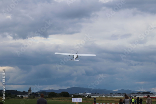 Yaslo, Poland - july 1 2018: A light sport turboprop aircraft flies across the sky among the rainy clouds. Landing in difficult weather conditions. Meteorology and weather forecast for aviation photo