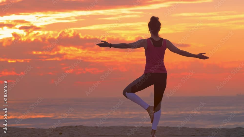 Woman practicing yoga on beach, summer sunset Woman practicing yoga on beach, summer sunset