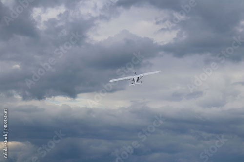 Yaslo, Poland - july 1 2018: A light sport turboprop aircraft flies across the sky among the rainy clouds. Landing in difficult weather conditions. Meteorology and weather forecast for aviation