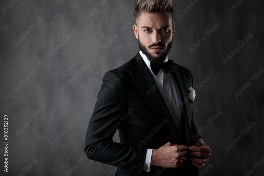 businessman standing and unbbutoning his jacket serious