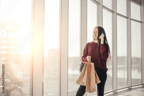Free Download Young brunette woman with shopping bags in city mall waiting for friend - GFXLoad