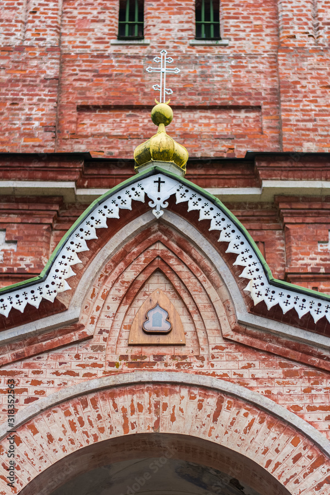 Fototapeta premium Old Orthodox church facade made of red bricks, visible Orthodox cross
