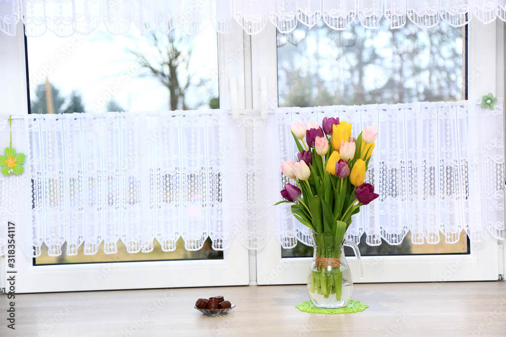 Klorowe tulipany w wazonie na parapecie białego wspłóczesnego okna w jasnej kuchni. - obrazy, fototapety, plakaty 