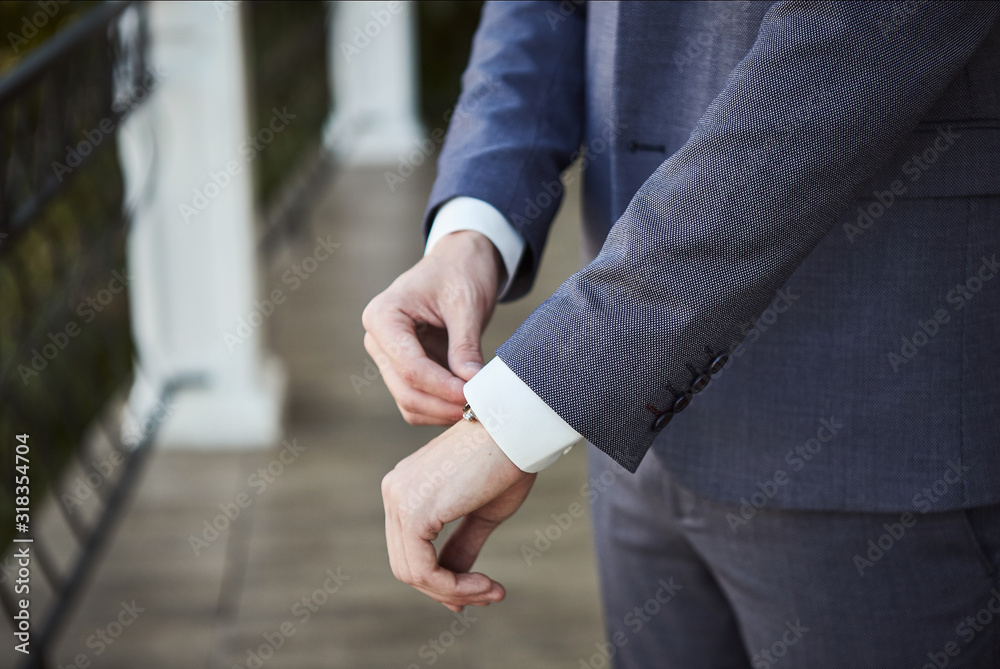Fototapeta premium Businessman wears a jacket,male hands closeup,groom getting ready in the morning before wedding ceremony