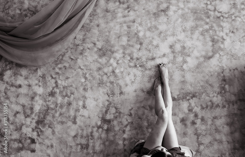 Young girl lying on the floor lifted her legs up