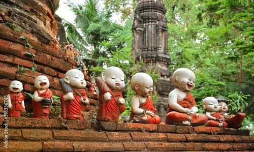 Sculpture of little monks with bowls at the buddhists temple in Ayutthaya photo