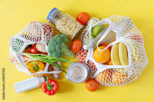 Fototapeta Naklejka Na Ścianę i Meble -  Cotton mesh bag for grocery with fruits and vegetables. Zero waste, no plastic shopping. Sustainable lifestyle concept.