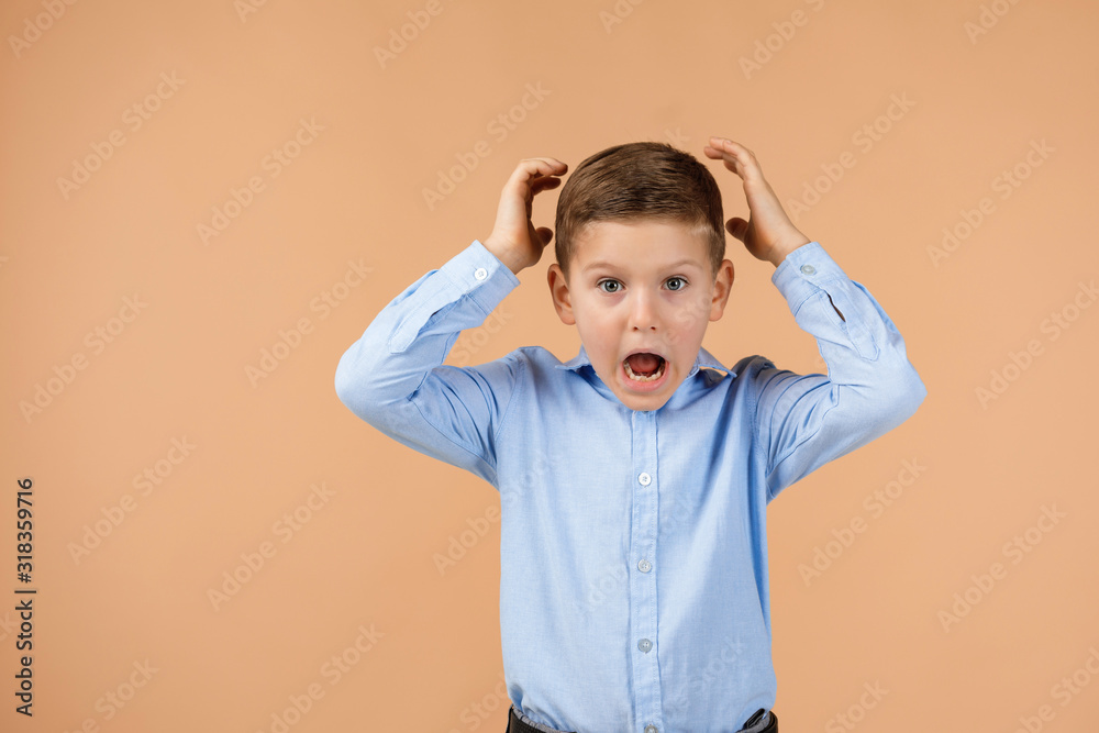 happy surprised little child boy looking to camera on beige background. Human emotions and facial expression happy surprised little child boy looking to camera on beige background. Human emotions and facial expression