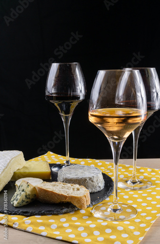 French cheese and Wine. Rosé and Bourgogne in glasses. Cheese board and yellow napkin