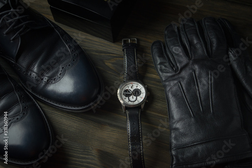 wristwatch lie next to shoes and gloves