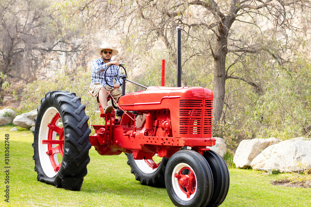 Handsome man with sunglasses driving the tractor to work on the farm Handsome man with sunglasses driving the tractor to work on the farm