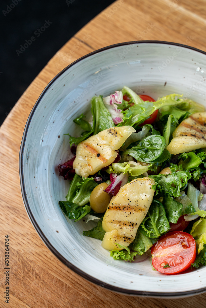 Halloumi cheese salad with mixed greens and tomatoes top view Halloumi cheese salad with mixed greens and tomatoes top view