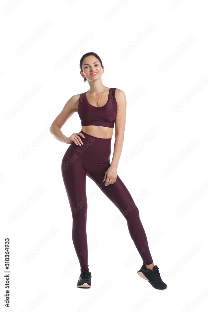 Beautiful slim woman in sportswear is standing in full growth isolated on white background.