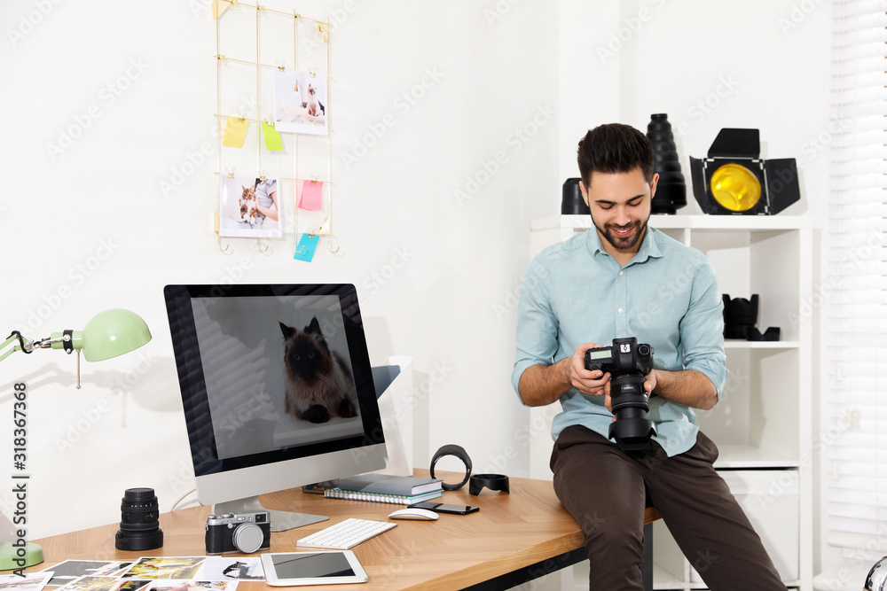 Professional photographer with camera working in light modern office