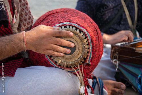 A devotee playing a mridangam, a percussion instrument photo
