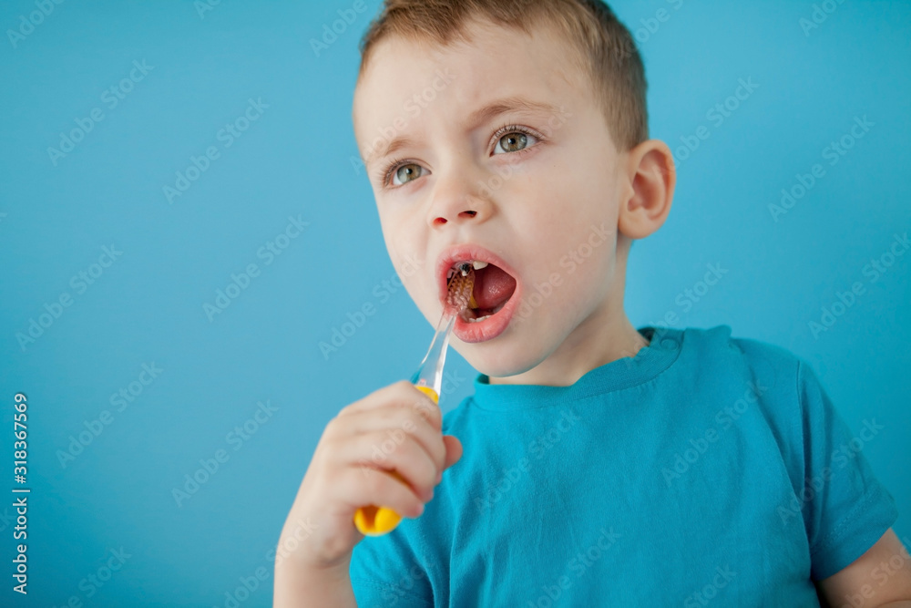 Little cute boy brushing his teeth on blue background Little cute boy brushing his teeth on blue background