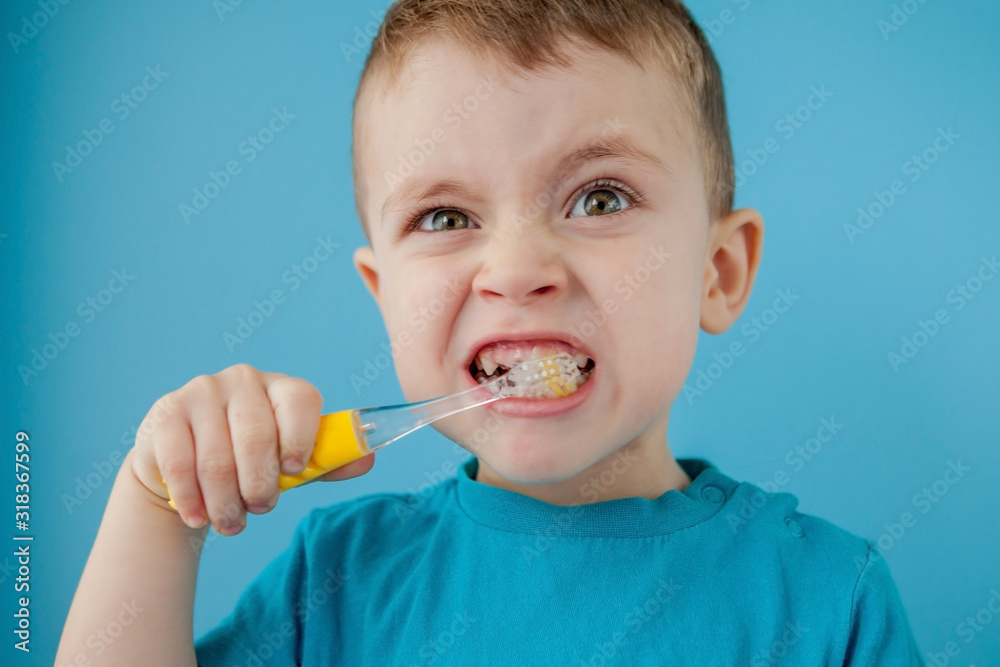 Little cute boy brushing his teeth on blue background Little cute boy brushing his teeth on blue background