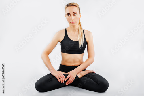 Sport blond girl in tracksuit for sport exercises on a white background