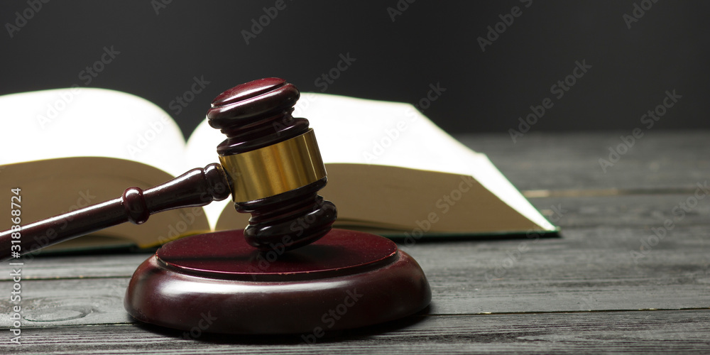 Law concept - Open law book with a wooden judges gavel on table in a courtroom or law enforcement office isolated on white background. Copy space for text. Law concept - Open law book with a wooden judges gavel on table in a courtroom or law enforcement office isolated on white background. Copy space for text.