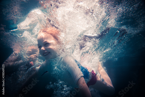 Happy child toddler fun swimming underwater during summer beach holidays vacation