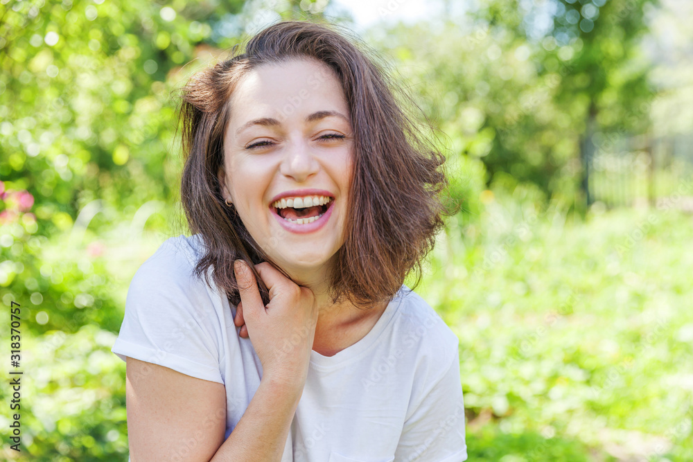 Happy girl smiling outdoor. Beautiful young brunete woman with brown hair resting on park or garden green background. European woman. Positive human emotion facial expression body language. Happy girl smiling outdoor. Beautiful young brunete woman with brown hair resting on park or garden green background. European woman. Positive human emotion facial expression body language.