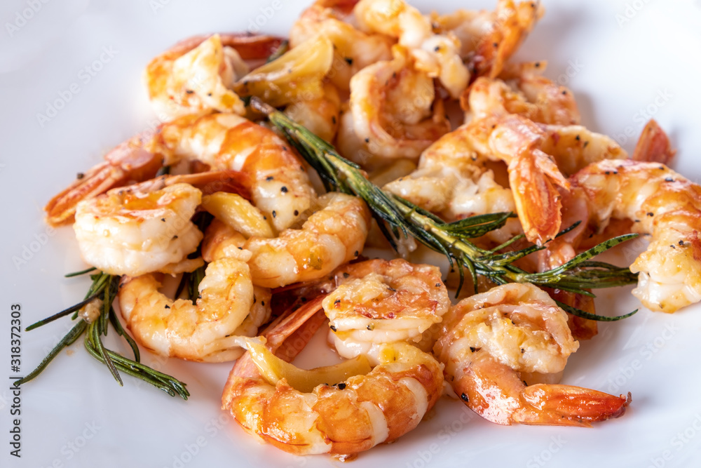 Fried or Roasted tiger big shrimps in plate with spice, lime, rosemary and lemon. Grilled seafood. Healthy food. Prawns Scampi traditional dish. Appetizer langoustines.Top view. Space for text Fried or Roasted tiger big shrimps in plate with spice, lime, rosemary and lemon. Grilled seafood. Healthy food. Prawns Scampi traditional dish. Appetizer langoustines.Top view. Space for text