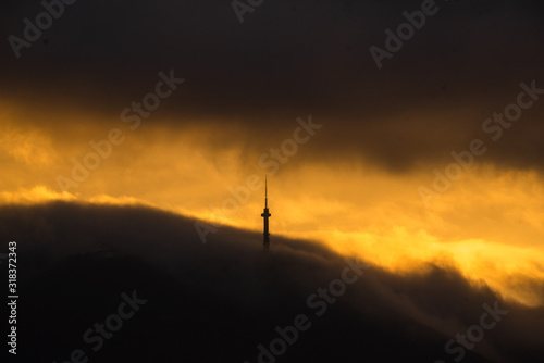 Communication tower in clouds golden sunset space for text natural beauty landscape gold smog mountain