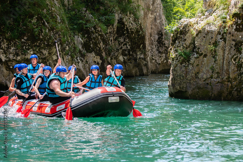 Rafting team goes down the river on the beautiful sunny day.