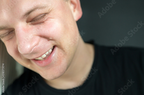 Junger Mann lacht Tränen während eines Lachanfalls photo