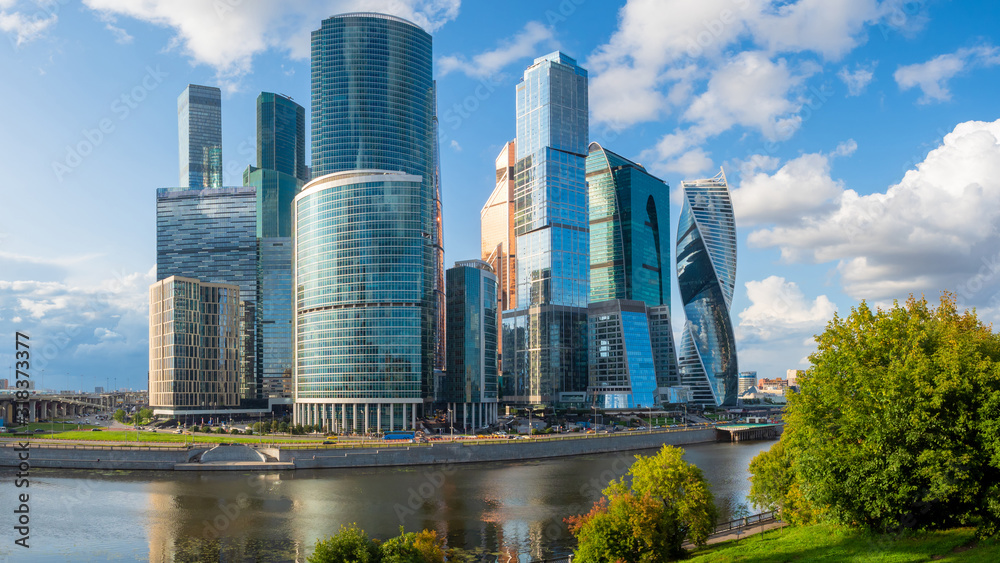 Obraz premium Skyscrapers on the background of water. Towers of glass and concrete. Skyscrapers. Modern architecture. Center of business activity. High-rise buildings with large Windows.