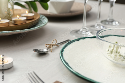 Foto Elegant spoon tied with twine on white wooden table, closeup