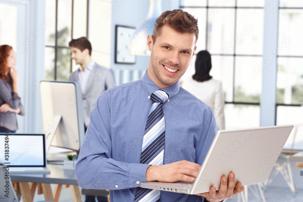 Happy young broker at business office with laptop Happy young broker at business office with laptop