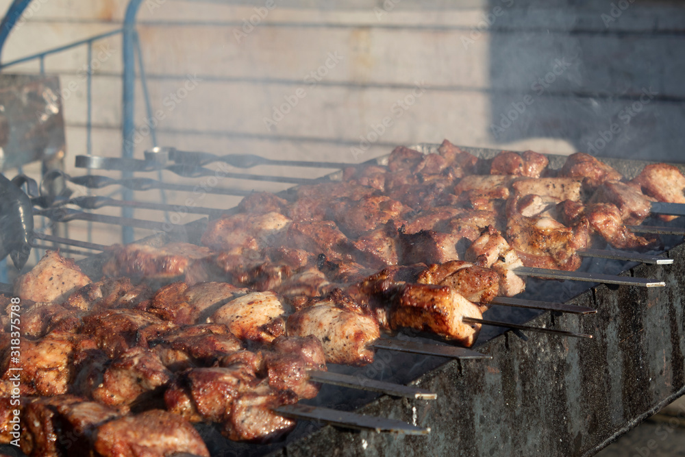 On the grill are skewers with pieces of meat. There is a process of frying barbecue. On the grill are skewers with pieces of meat. There is a process of frying barbecue.