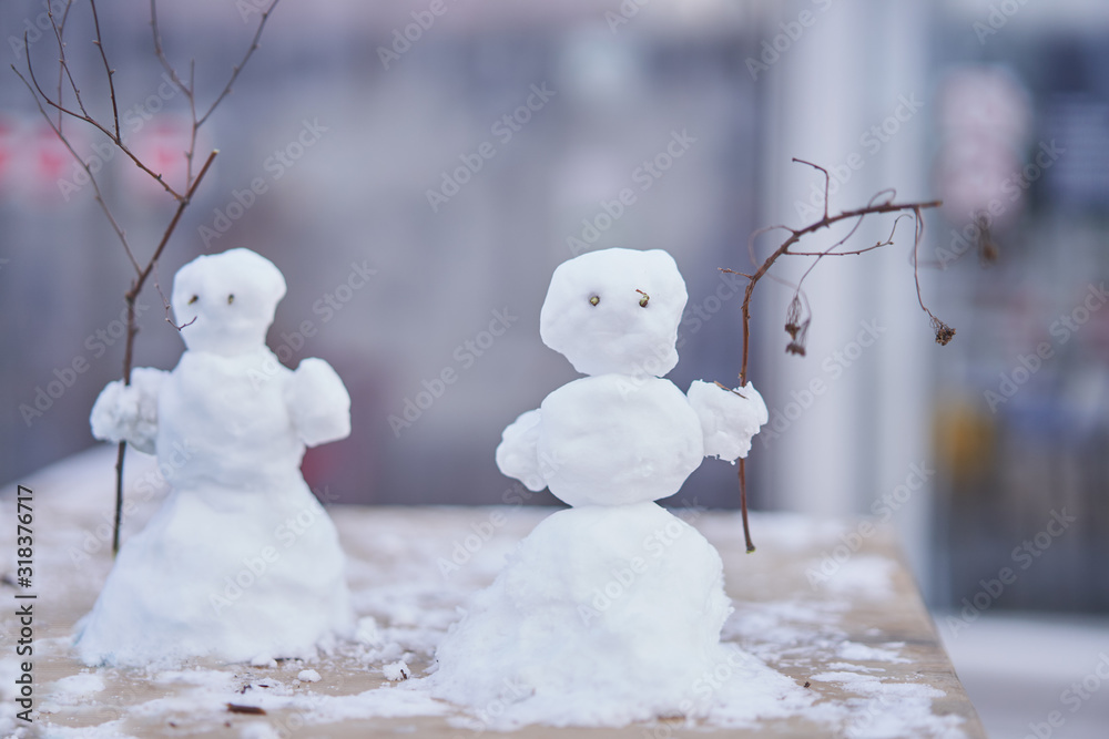 Two little cute snowmen with branches instead of hands Two little cute snowmen with branches instead of hands