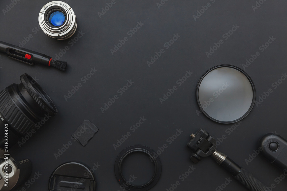 Photographer workplace with dslr camera system, camera cleaning kit, lens and camera accessory on dark black table background. Hobby travel photography concept. Flat lay top view copy space. Photographer workplace with dslr camera system, camera cleaning kit, lens and camera accessory on dark black table background. Hobby travel photography concept. Flat lay top view copy space.